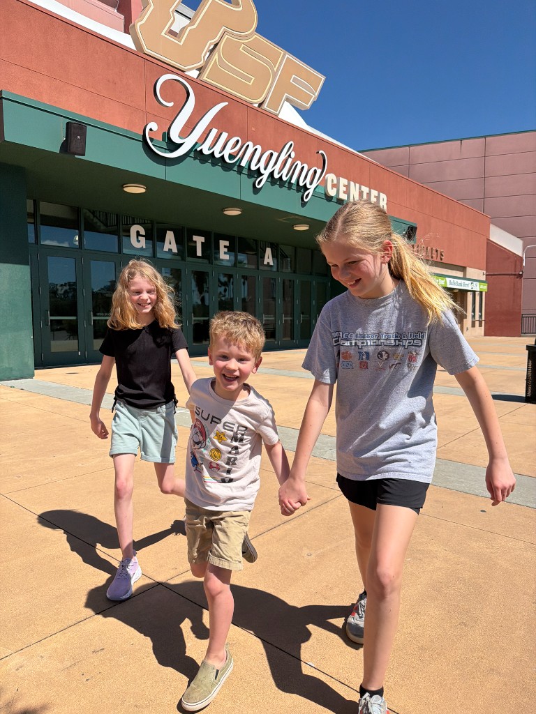 Three children in front of USF Yuengling Center, Gate A — To·Gather Kids